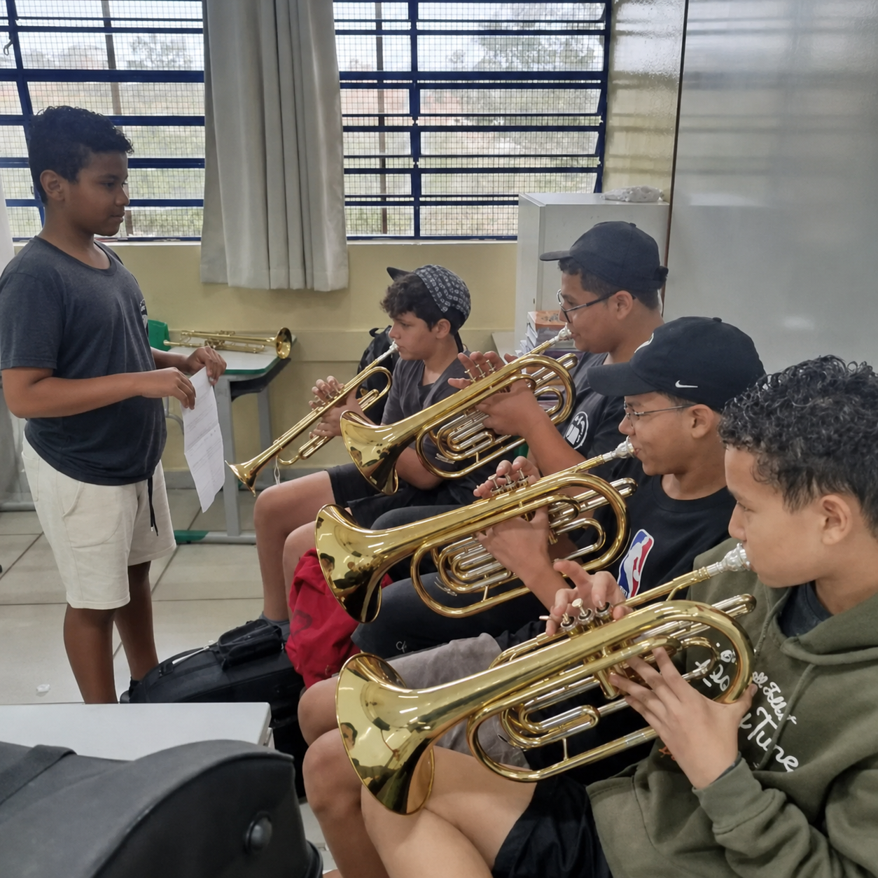 Apresentação no palco com saxofonista e alunos ao fundo.