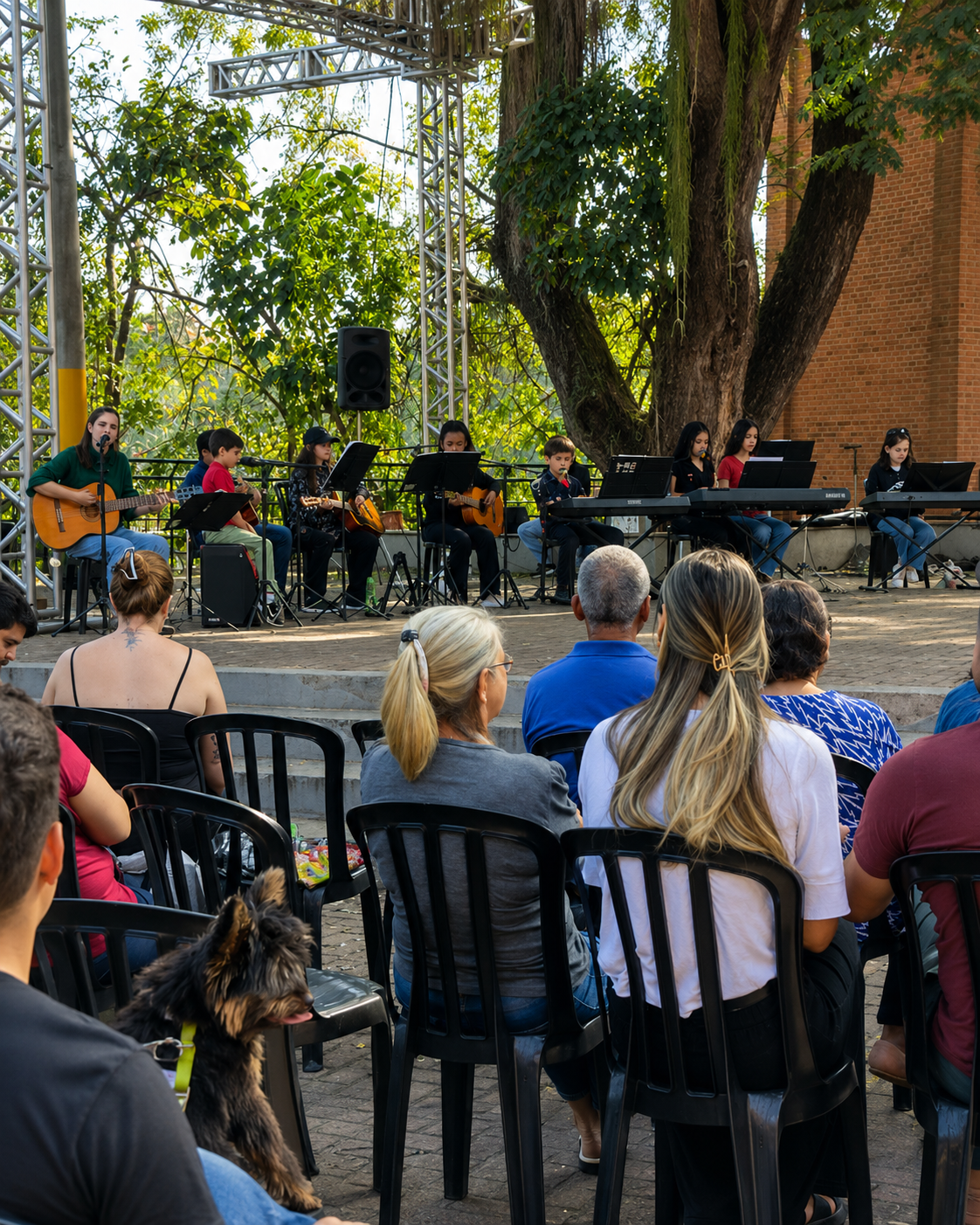 Apresentação coletiva em palco com alunos e músicos.